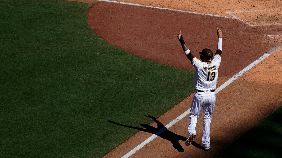 Manny Machado reacts as he scores from third