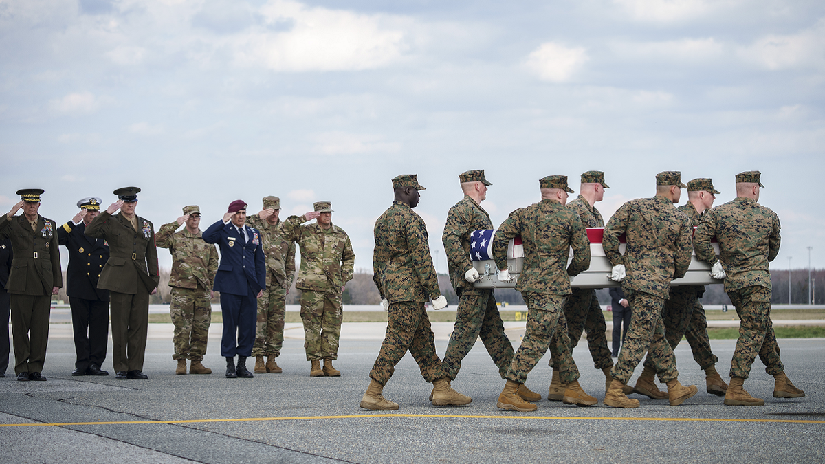 Military members carrying casket