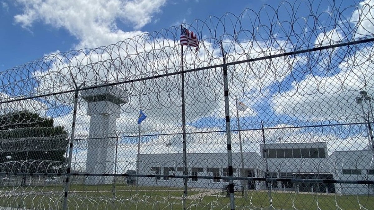 Exterior image of ODOC facility behind barbed wire