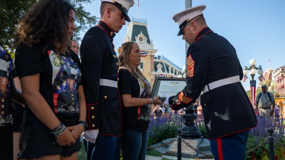 Soldiers hand American flag to mother of Marine killed