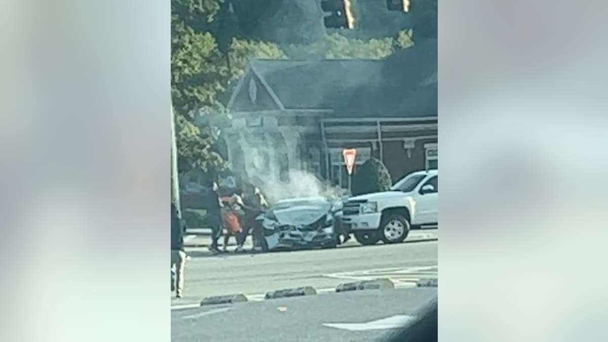 Football players rush to help woman stuck in car after a crash