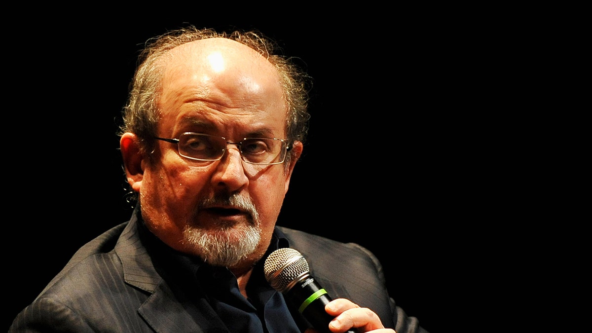 Salmon Rushdie author holding microphone