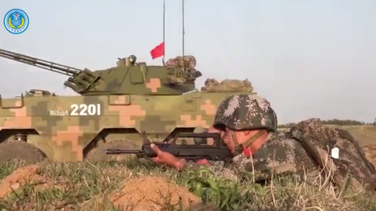 Chinese soldier with weapon and tank