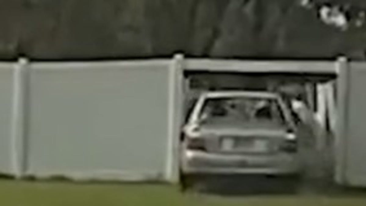 Car driving through fence