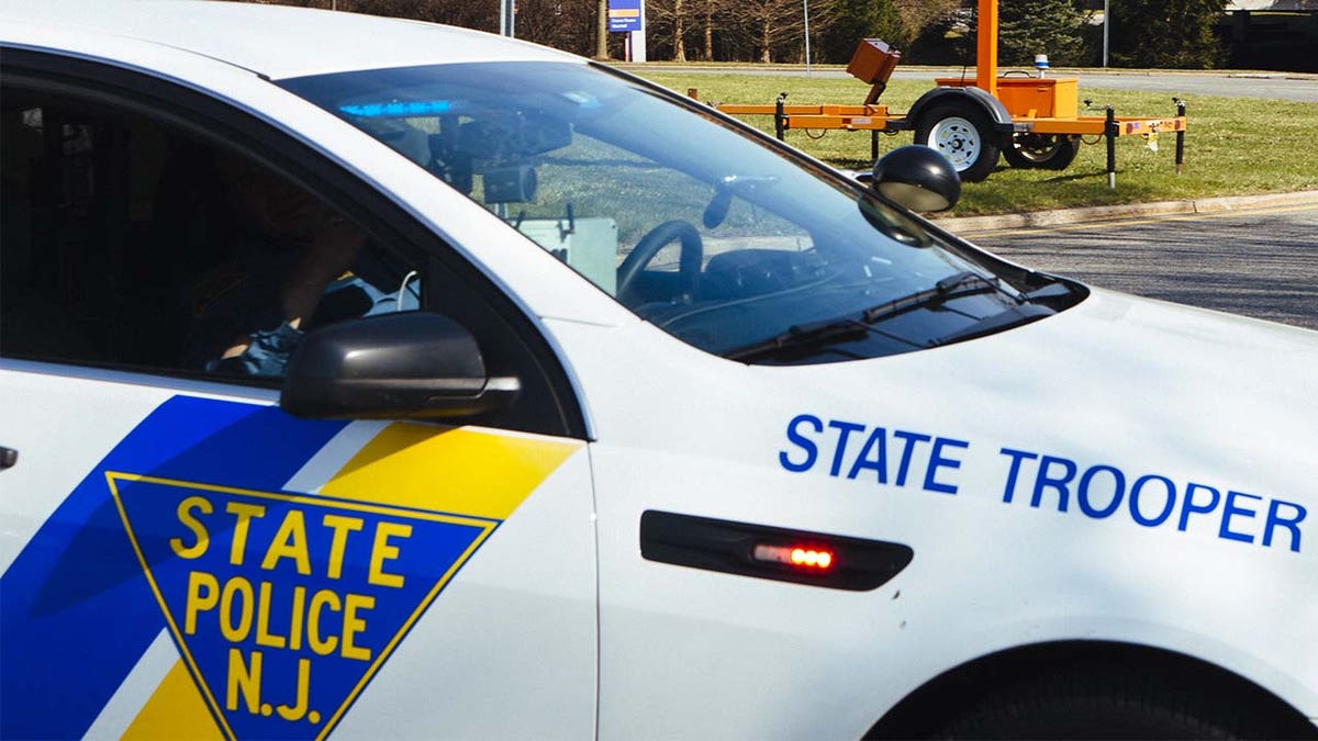 NJ State Police logo on a white police vehicle