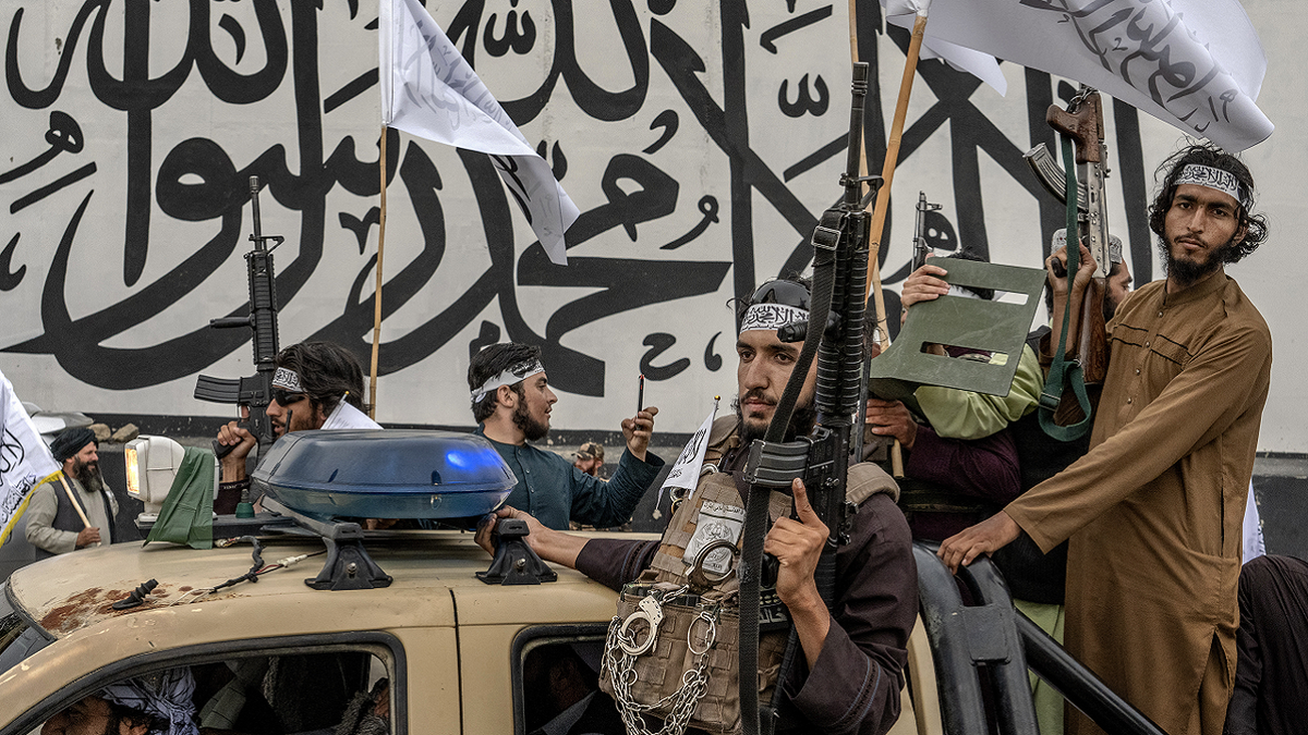 Combatientes talibanes en camiones con armas
