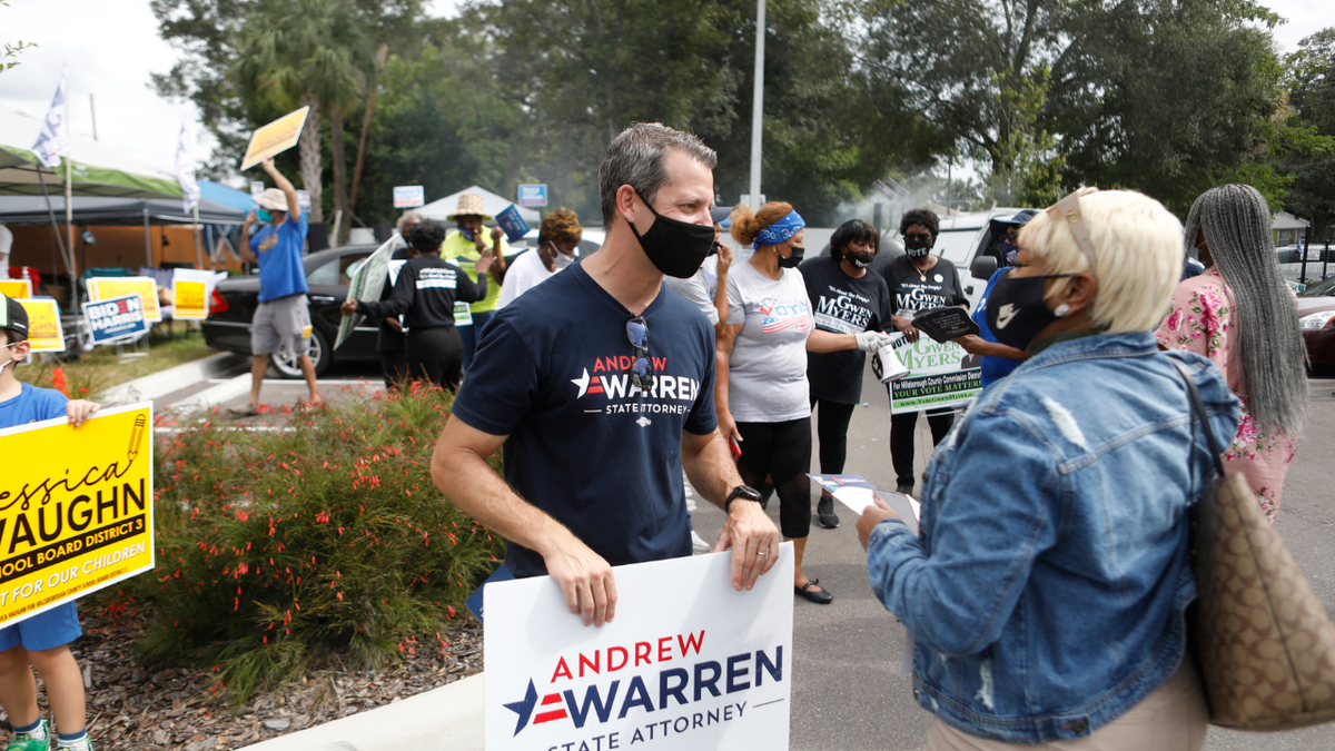 Hillsborough County State Attorney Andrew Warren campaigns, wearing a mask