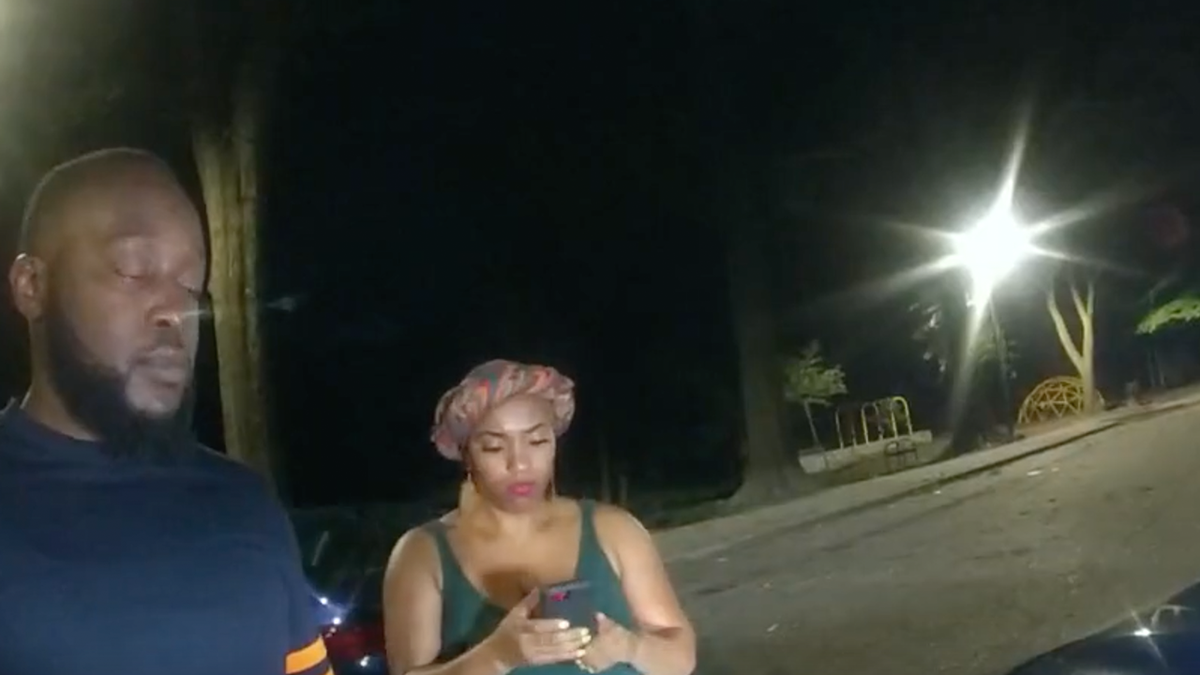 Photo shows woman on her phone as an Atlanta police officer tries to give two people tickets for being in a park after hours