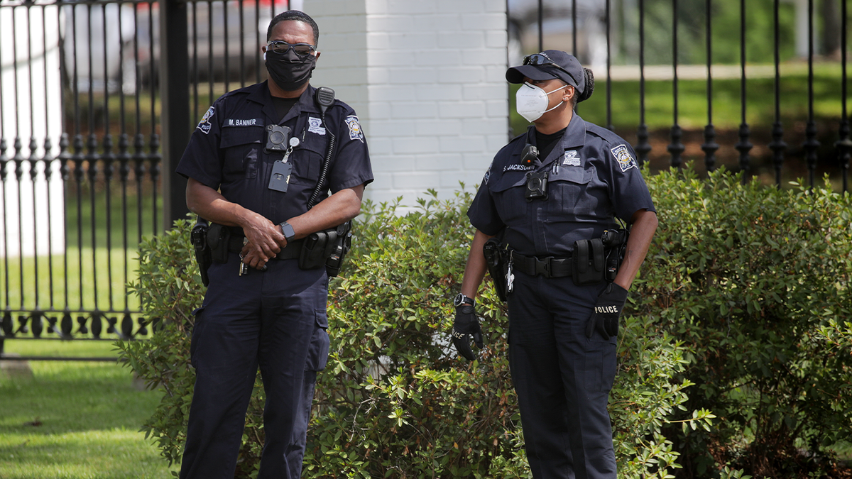 Photo shows two Baton Rouge officers wearing face masks while standing outside during a protest