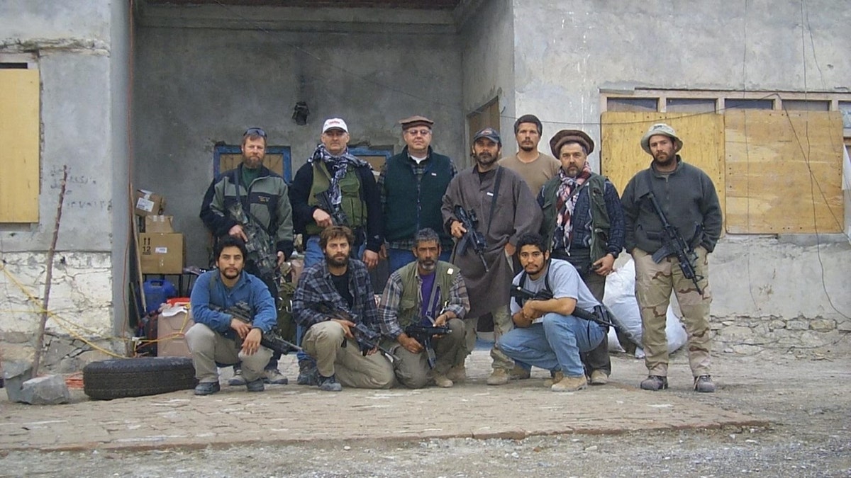 US soldiers and Afghan allies pose for picture in front of blank building