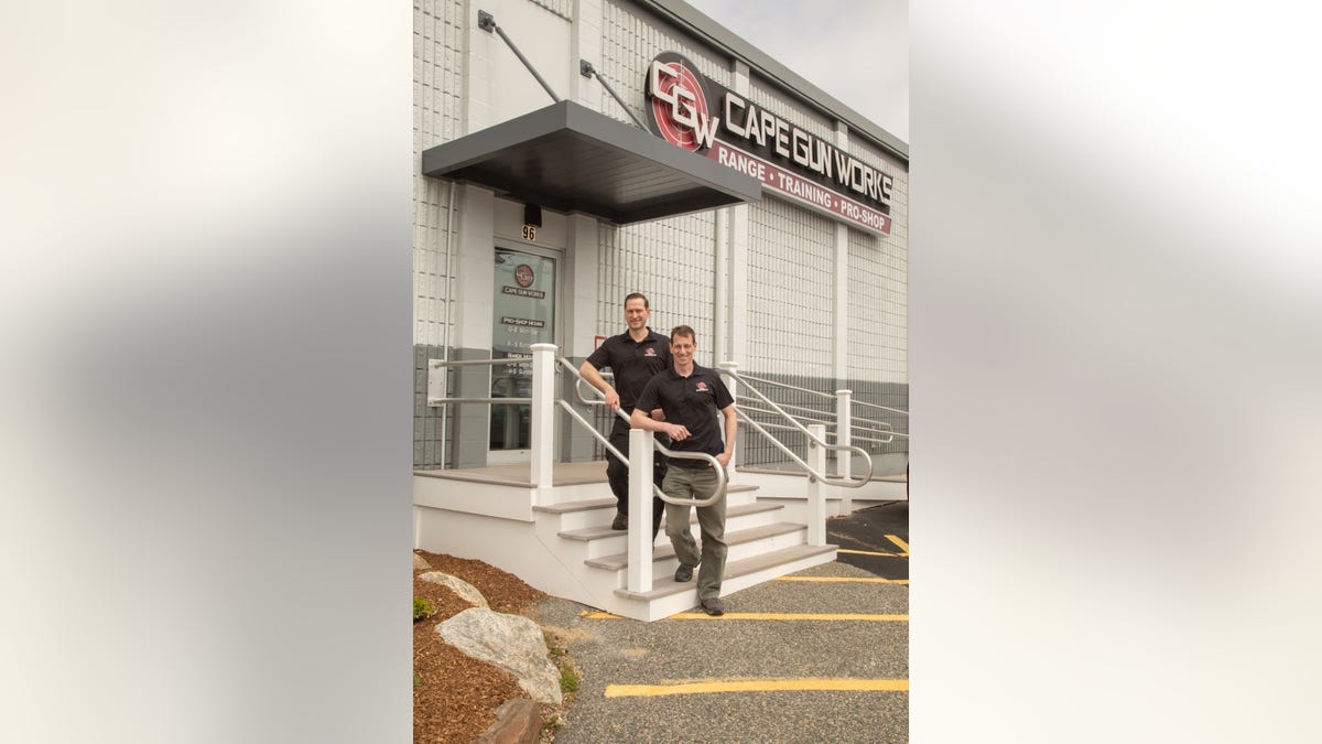 Photo of owners of Cape Gun Works standing outside their store.