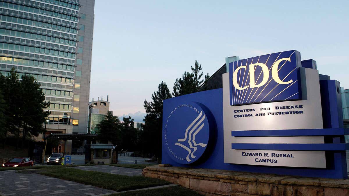 CDC headquarters with logo to the right and the building behind it to the left