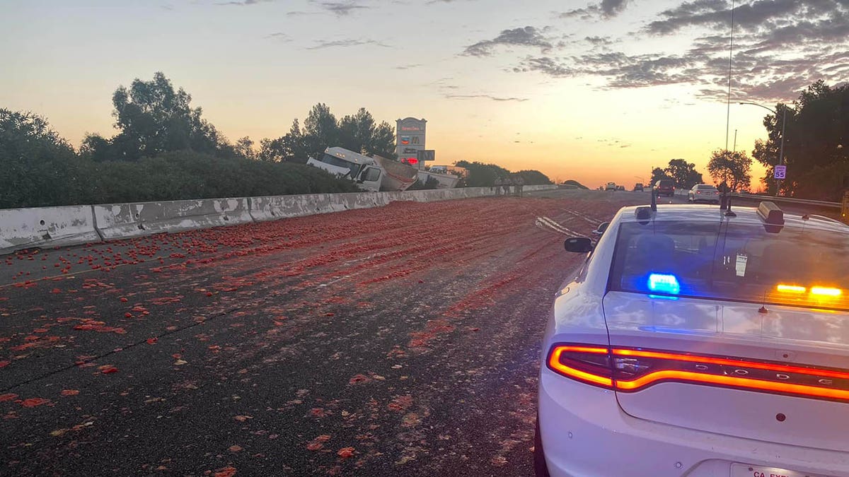 police car closing lane after tomato spill