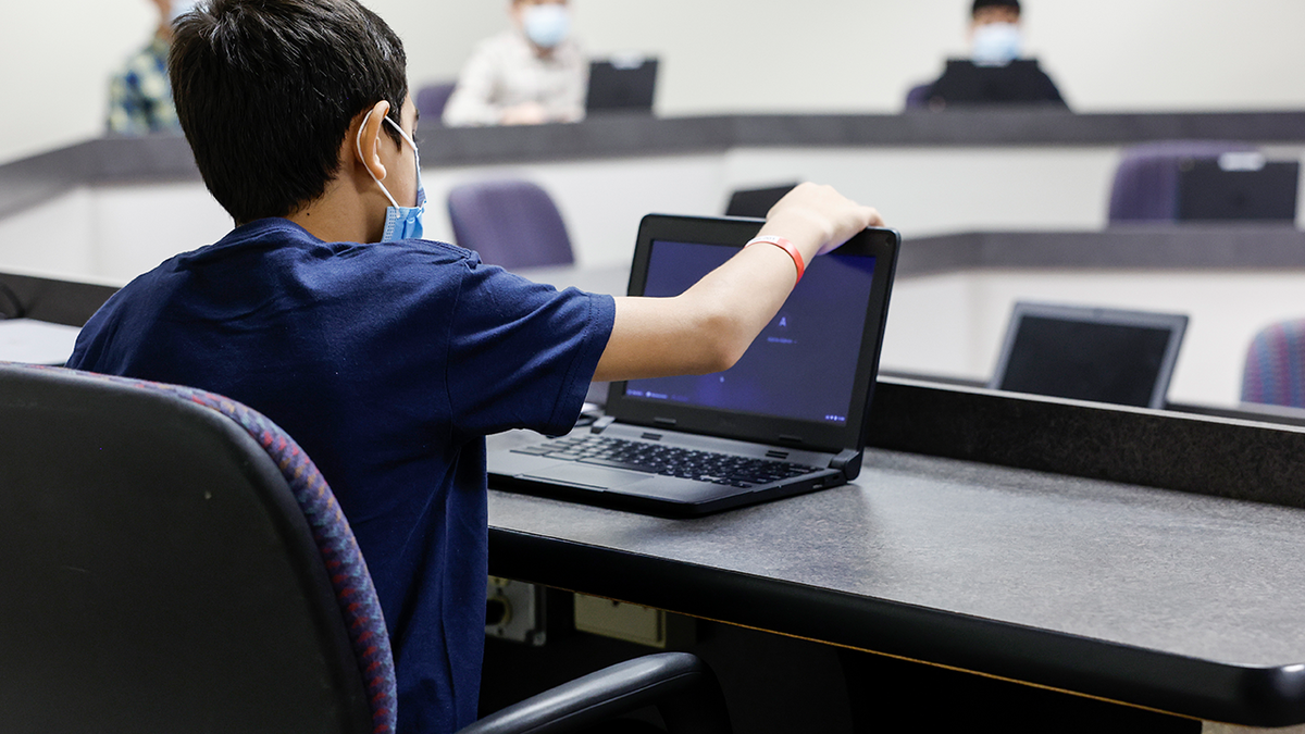 Photo of young boy adjusting computer screen while at National Conference Center in Virginia
