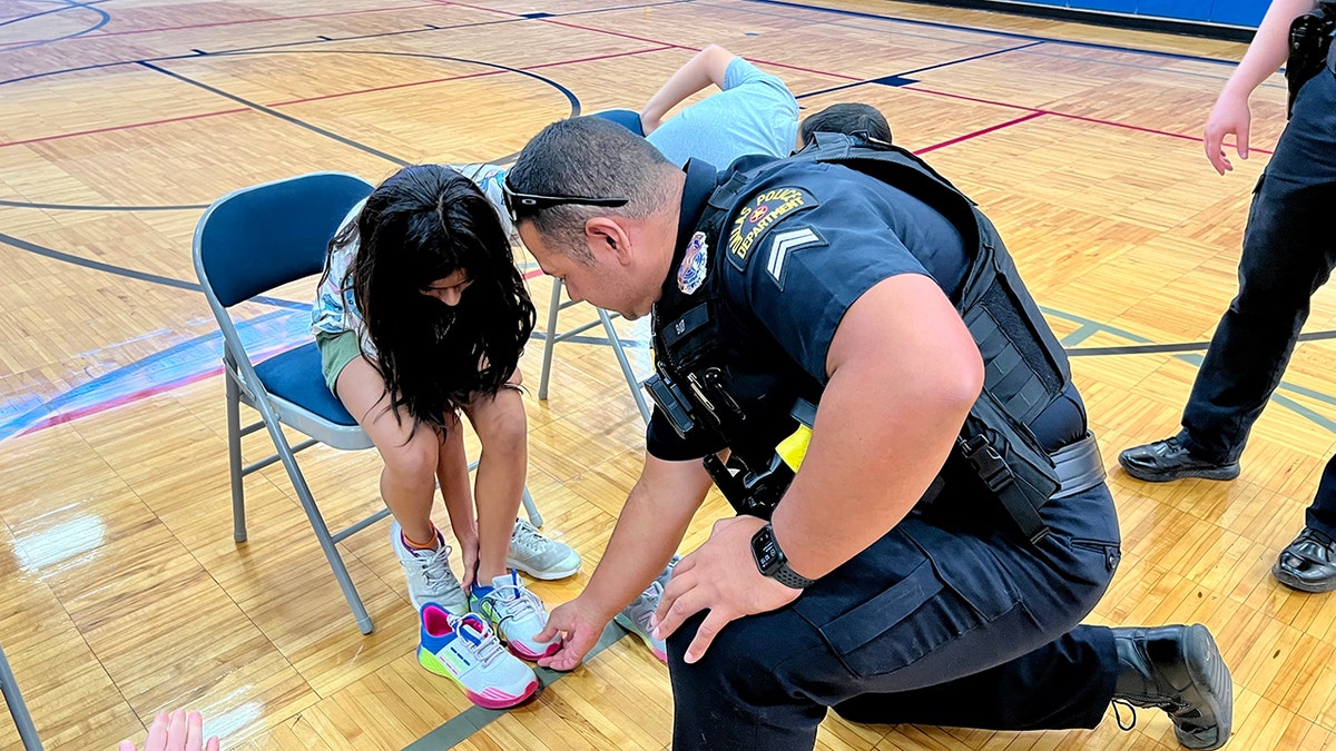 a Dallas-area police officer helps a child with new shoes