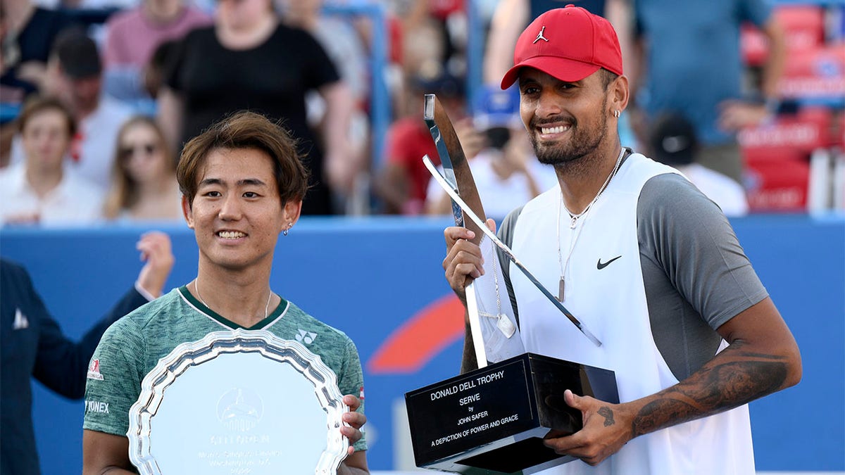 Nick Kyrgios poses with Yoshihito Nishioka with trophies