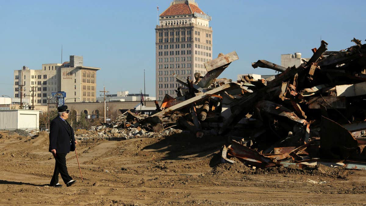 Man walks past rubble of building cleared for California High Speed Rail