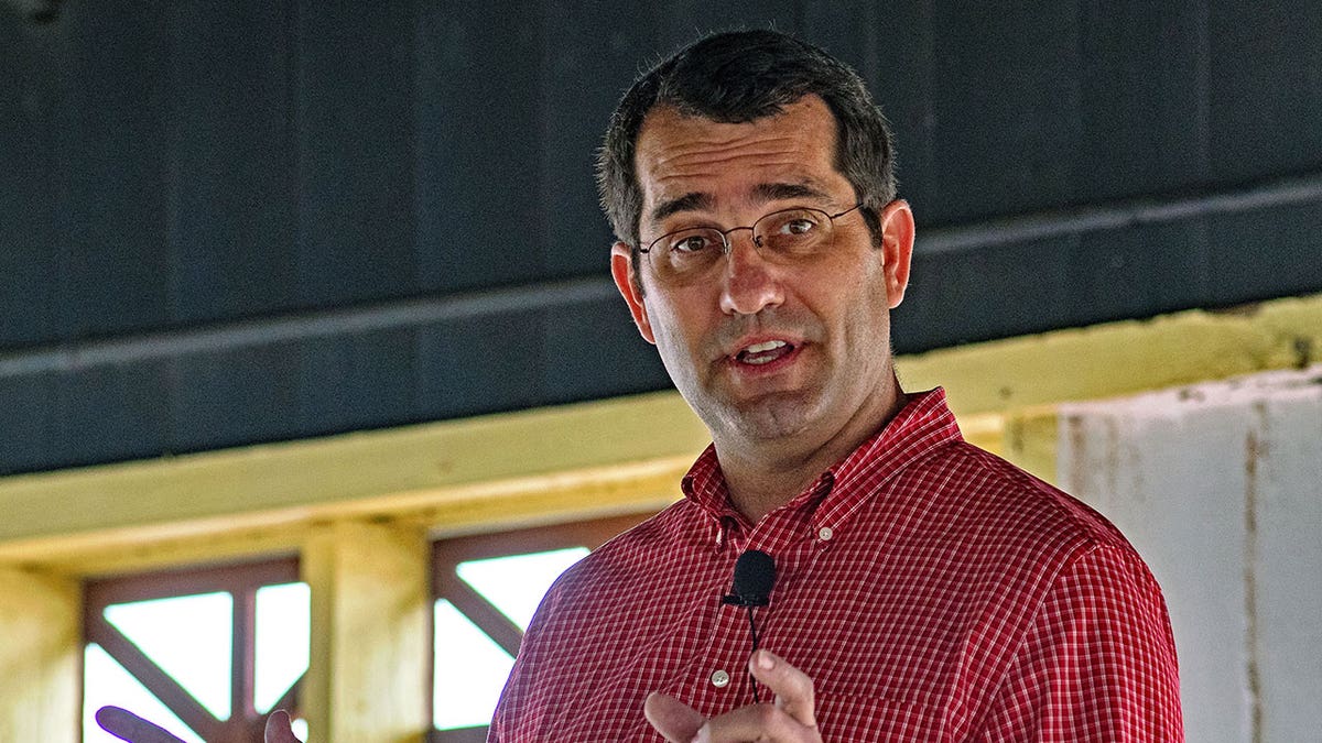 Kansas AG Derek Schmidt wears a red button down during a speech