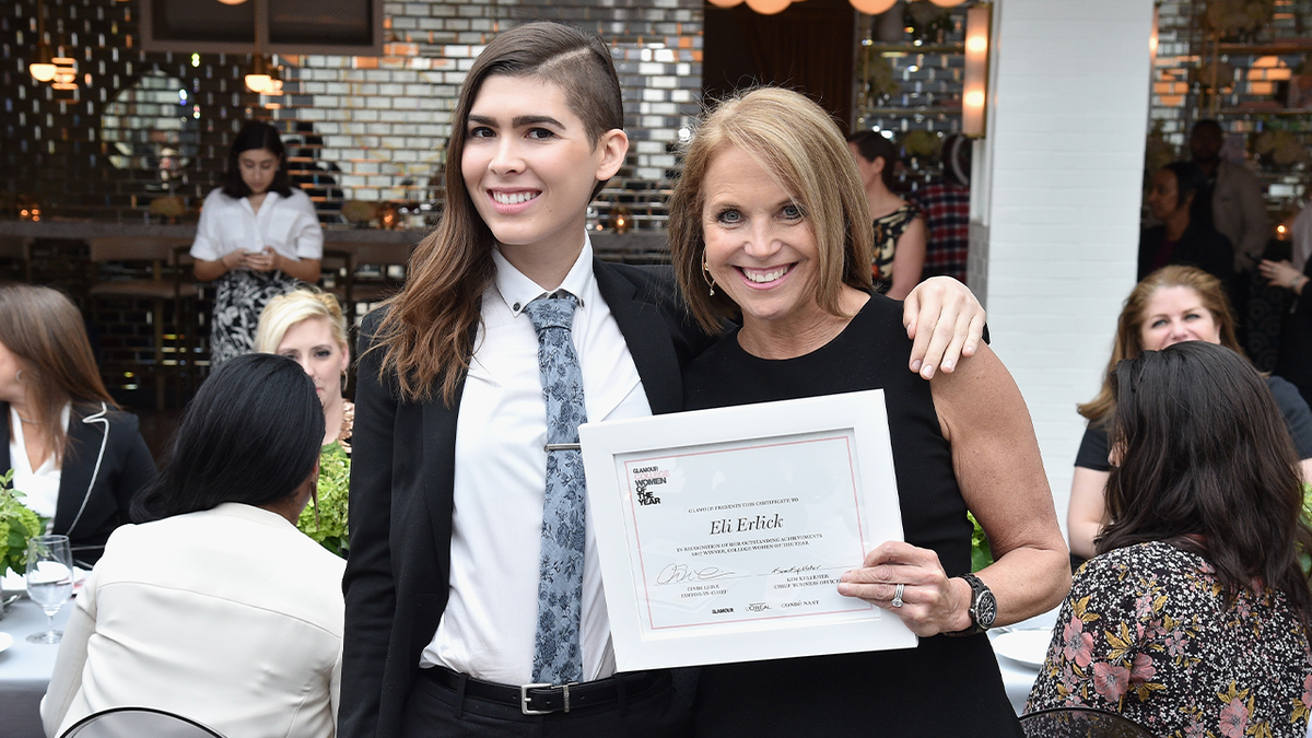 Transgender activist Eli Erlick in a suit with Katie Couric at awards ceremony