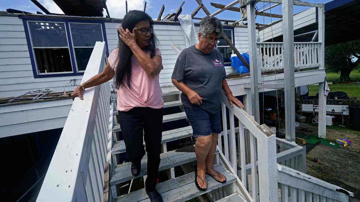 Members of the United Houma Nation India tribe walk around a home destroyed from Hurricane Ida. FEMA announces a new strategy to better engage with Native American tribes who face climate-change related disasters.