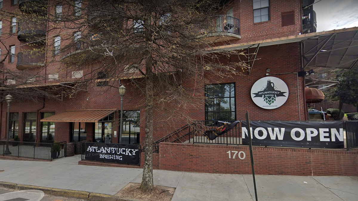 Photo shows the outside of Atlanta brewery called Atlantucky Brewery, with Now Open signs 