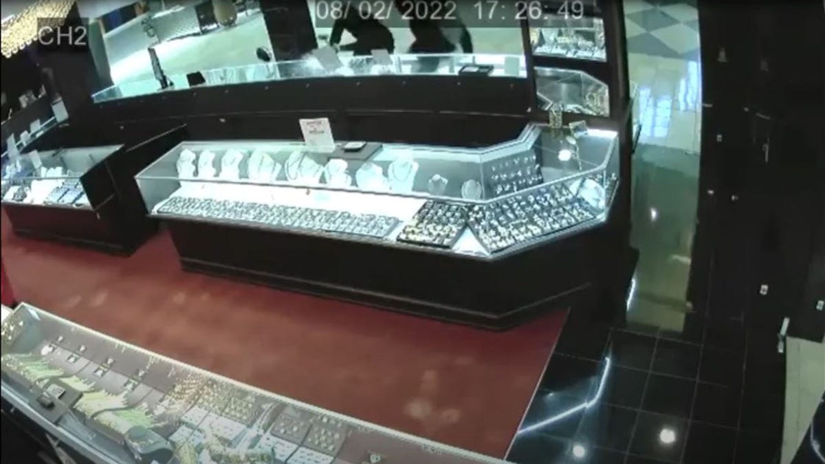 Thieves smashing jewelry cases in surveillance photo