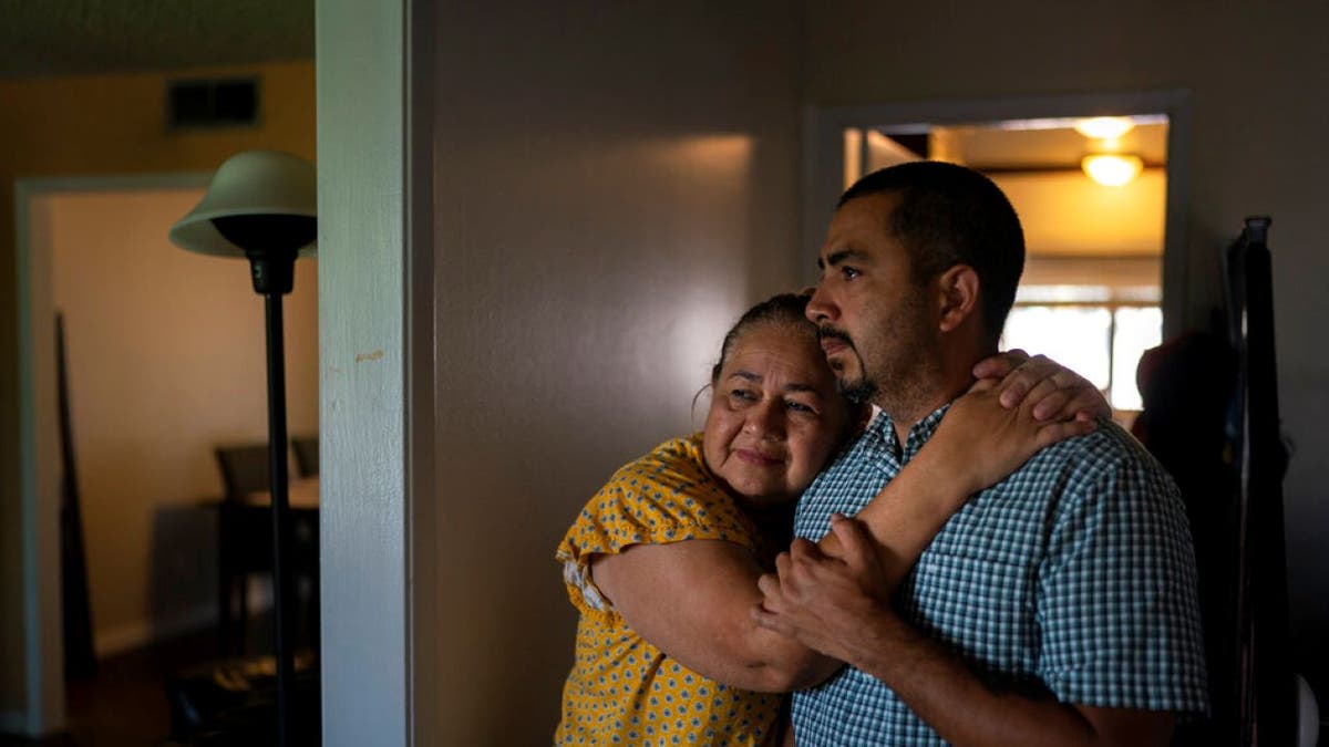 Mother of Eyvin Hernandez hugging his half brother wearing yellow dress