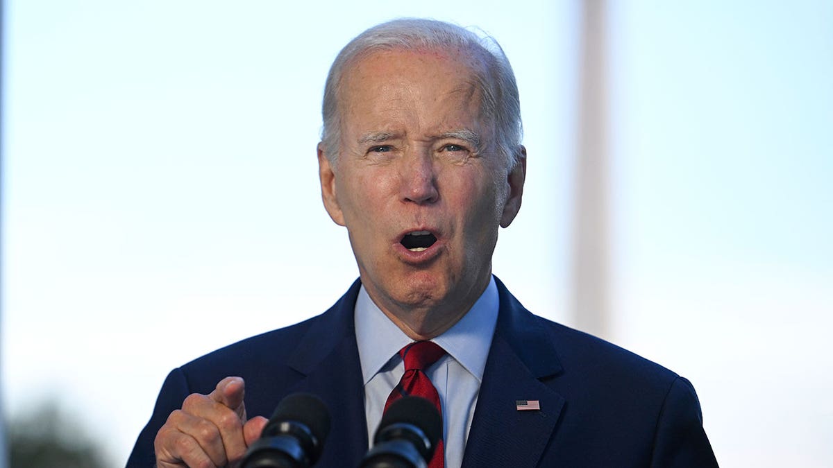 Joe Biden giving a speech from the Blue Room Balcony in a suit and tie during daytime