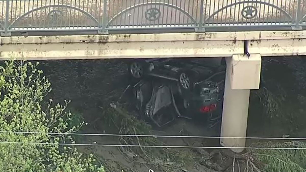 damaged car swept under bridge