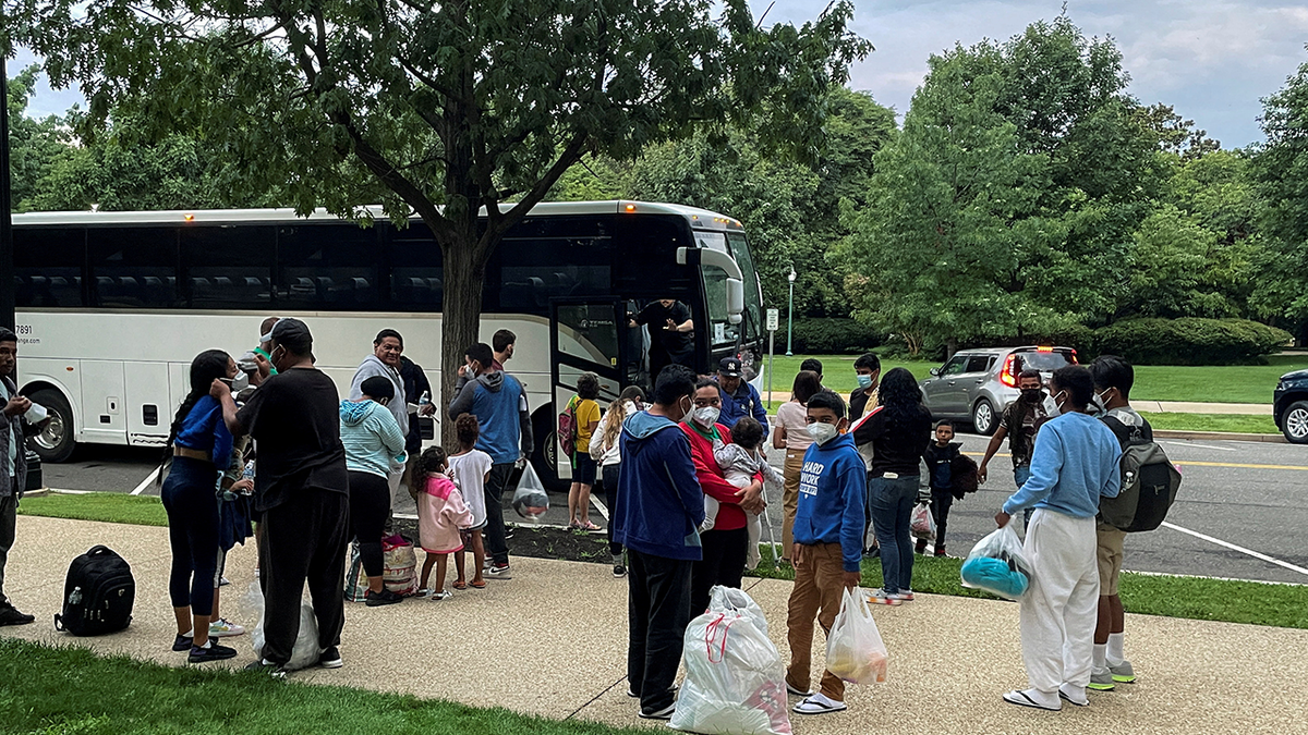 Photo taken in Washington, D.C., shows migrants leaving a bus that transported them from Texas
