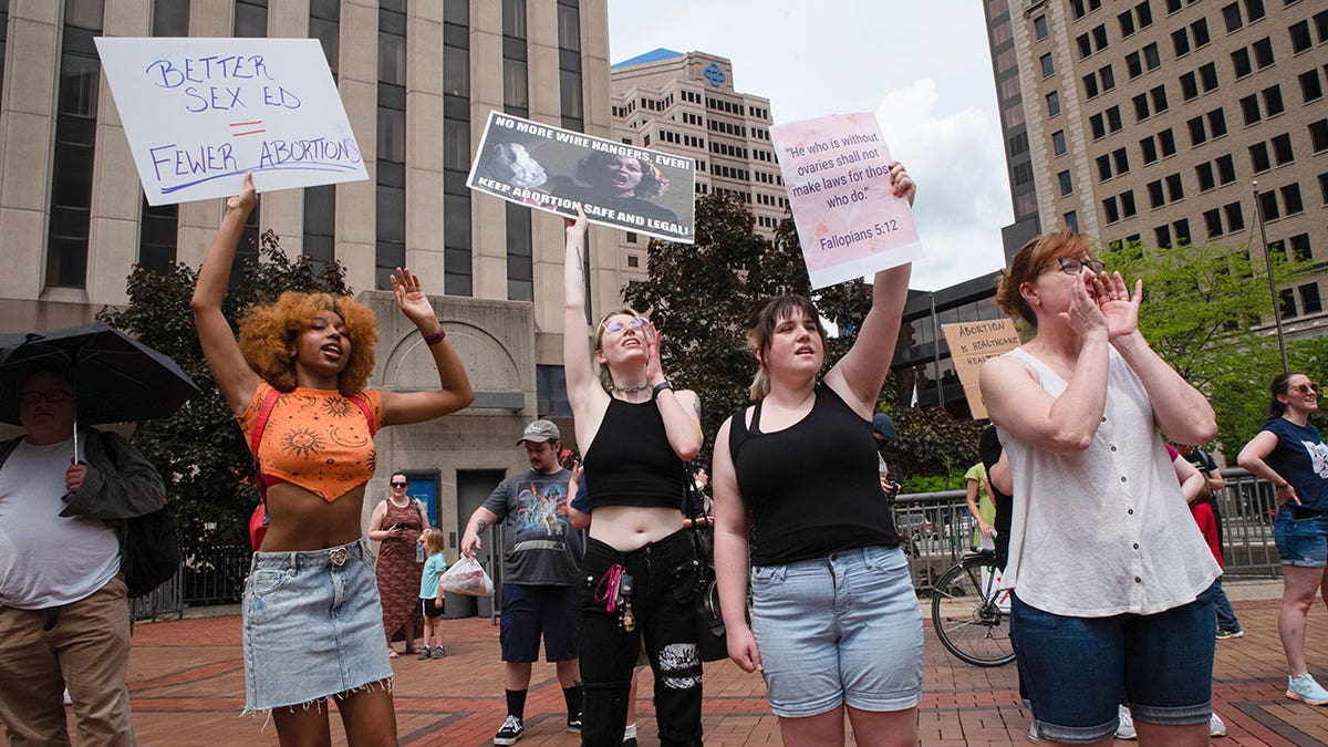 Abortion protestors stand with signs during daytime in Dayton, Ohio