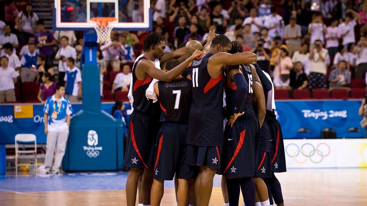 The 2008 Olympic men's basketball team in a huddle on the court