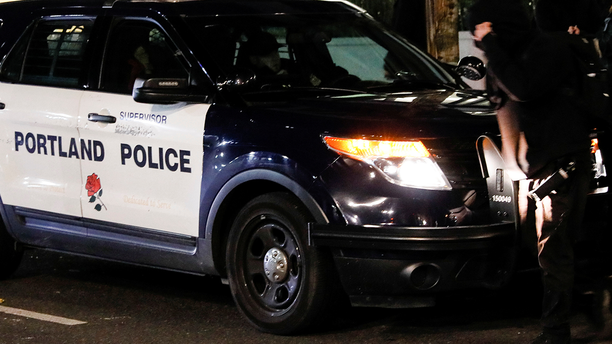 Protesters block a police car after the full acquittal verdict of teenager Kyle Rittenhouse in his Wisconsin fatal shootings trial, in Portland.