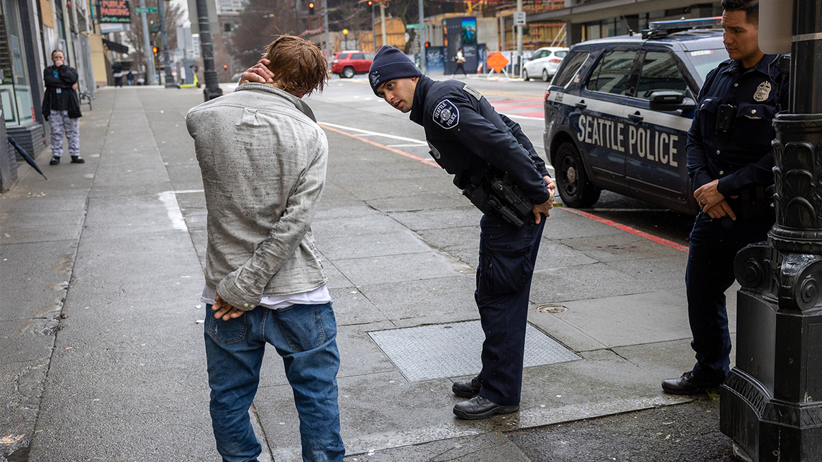Seattle police officers speak with a man who said he was smoking drugs.