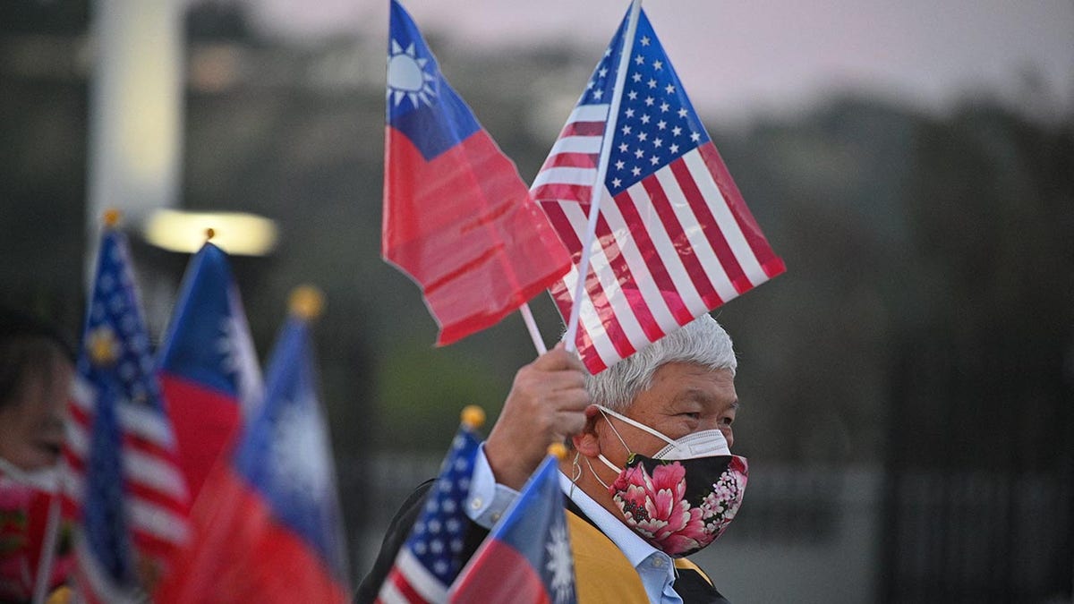 A man holds up the flags of Taiwan and the U.S.