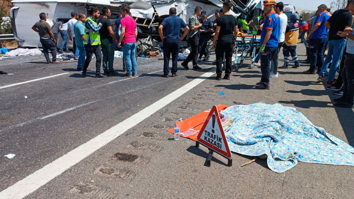 A body lies covered on a freeway in Turkey after a bus crash