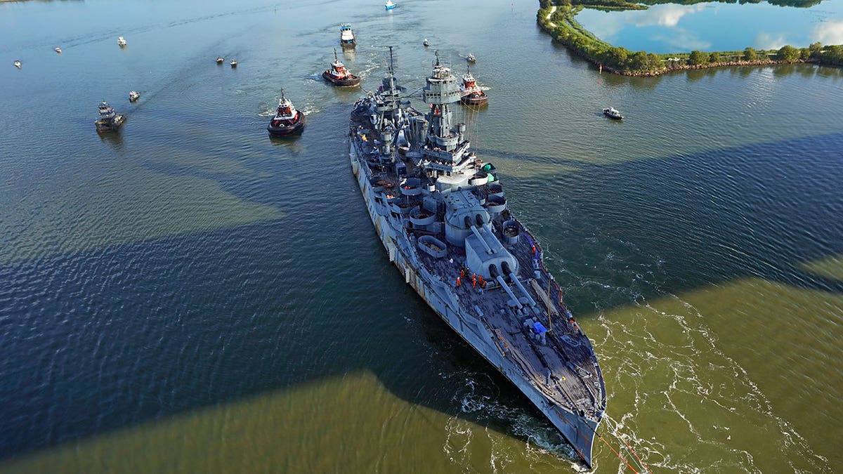 Aerial shot of the USS Texas in a channel of water during daytime