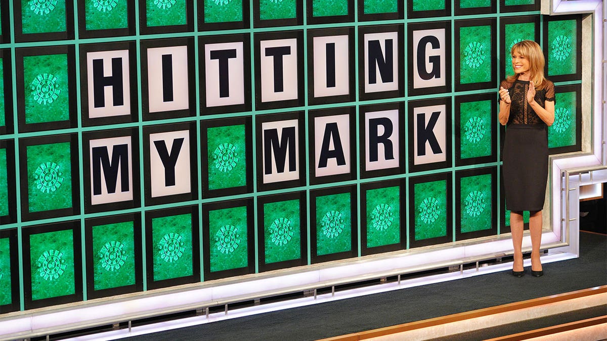 Vanna White standing in front of "Wheel of Fortune" board