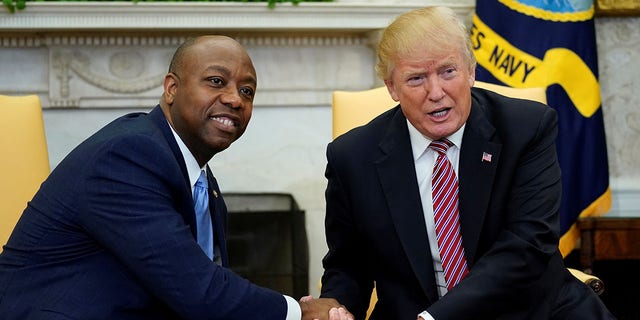U.S. President Donald Trump shakes hands with Senator Tim Scott during in a working session regarding the Opportunity Zones provided by tax reform in the Oval Office of the White House in Washington, U.S.
