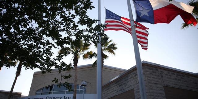 Flags fly at half mast outside the Galveston County Jail in Galveston, Texas, on May 18, 2018.  
