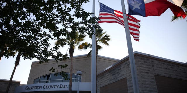 Flags fly at half mast outside the Galveston County Jail in Galveston, Texas, on May 18, 2018.