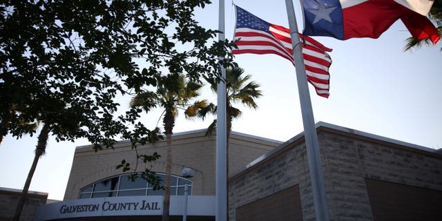 Flags fly at half mast outside the Galveston County Jail in Galveston, Texas, on May 18, 2018.  