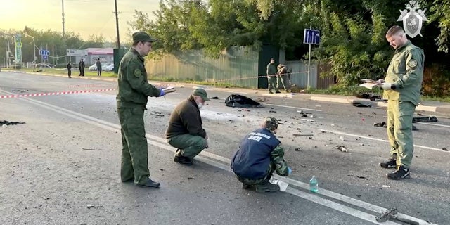 Следователи работают на месте предполагаемого взрыва заминированного автомобиля, в результате которого погибла Дарья Дугина, дочь ультранационалистического российского идеолога Александра Дугина, в Московской области 21 августа 2022 года, на этом неподвижном изображении, взятом из видео.