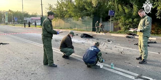 Investigators work at the site of a suspected car bomb attack that killed Darya Dugina, daughter of ultra-nationalist Russian ideologue Alexander Dugin, in the Moscow region, Russia August 21, 2022, in this still image taken from video. 