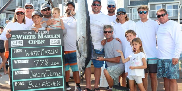 Jeremy Duffie, a fisherman from Bethesda, Maryland, poses with his family around the white marlin that earned him first place at the 2022 White Marlin Open. His catch weighed 77.5 pounds and earned him $4.4 million.