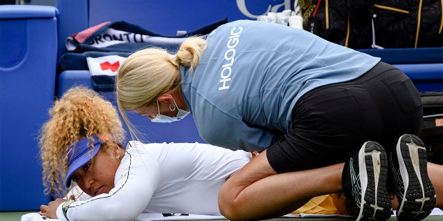 Naomi Osaka is favored by a coach during her match against Kaia Kanepi of Estonia at the National Bank Open tennis tournament, Tuesday, Aug. 9, 2022, in Toronto.