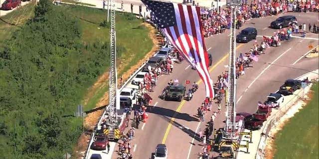 Americans crowd line the highway as a funeral procession for Jared drives by in Missouri.