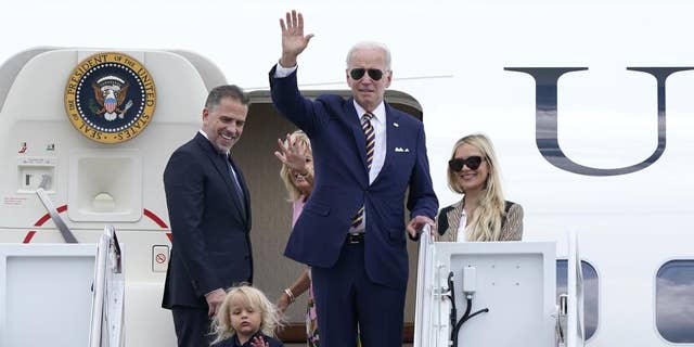 President Joe Biden, center, waves as he is joined by, from left, son Hunter Biden, grandson Beau Biden, first lady Jill Biden and daughter-in-law Melissa Cohen as they board Air Force One at Andrews Air Force Base in Maryland on Aug.  10, 2022.