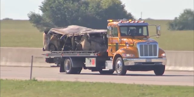 A charred van is hauled away from the scene of a crash in Illinois. Five children and their mother who were riding in the van were killed. The woman driving the car that hit them was also killed in the crash.