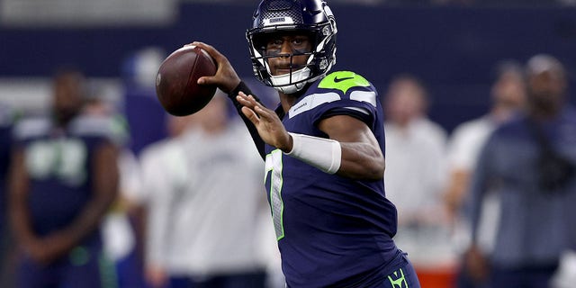 Quarterback Geno Smith #7 of the Seattle Seahawks looks for an open receiver against the Dallas Cowboys in the first quarter a NFL preseason football game at AT&T Stadium on Aug.  26, 2022, in Arlington, Texas.